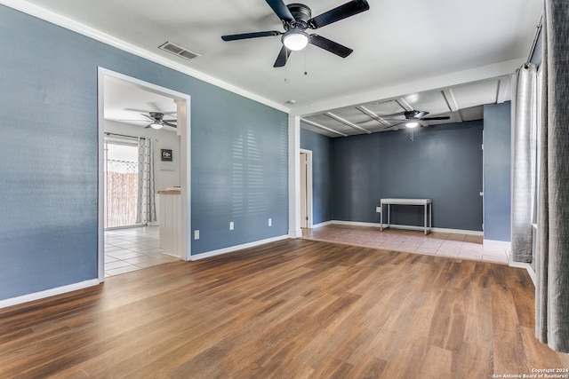 unfurnished room with light hardwood / wood-style floors and beamed ceiling