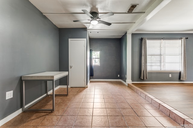 interior space featuring beam ceiling, decorative columns, ceiling fan, and light tile patterned floors