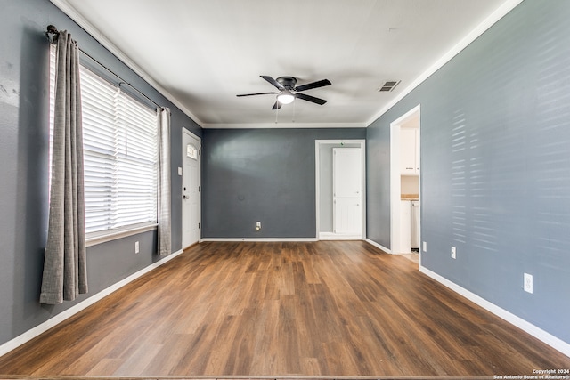 empty room with crown molding, ceiling fan, and dark hardwood / wood-style flooring