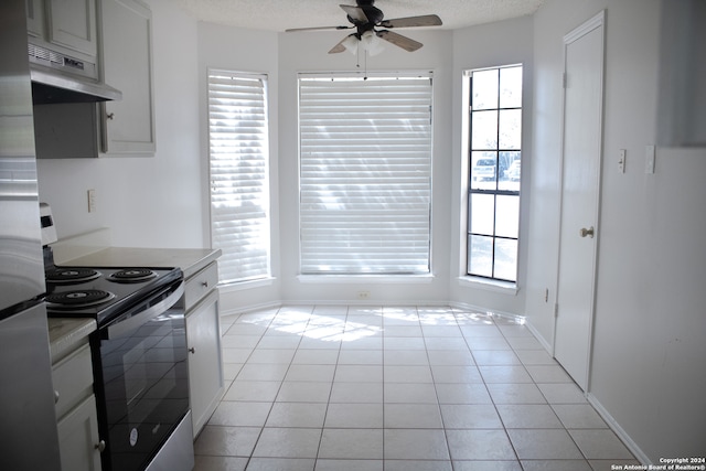 kitchen featuring ceiling fan, stainless steel range with electric stovetop, a textured ceiling, and light tile patterned floors