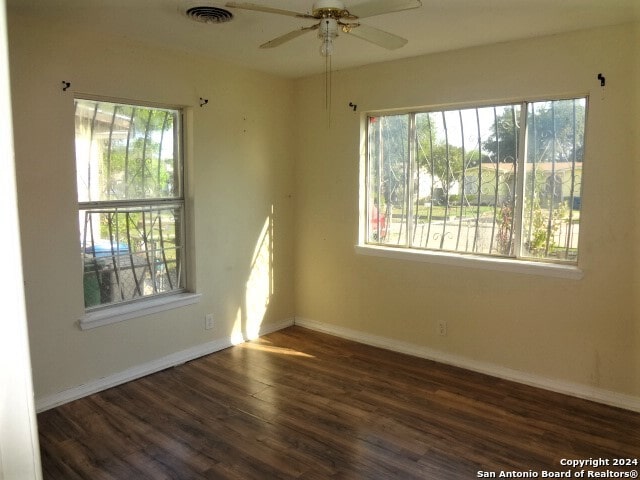 empty room featuring ceiling fan and dark wood-type flooring