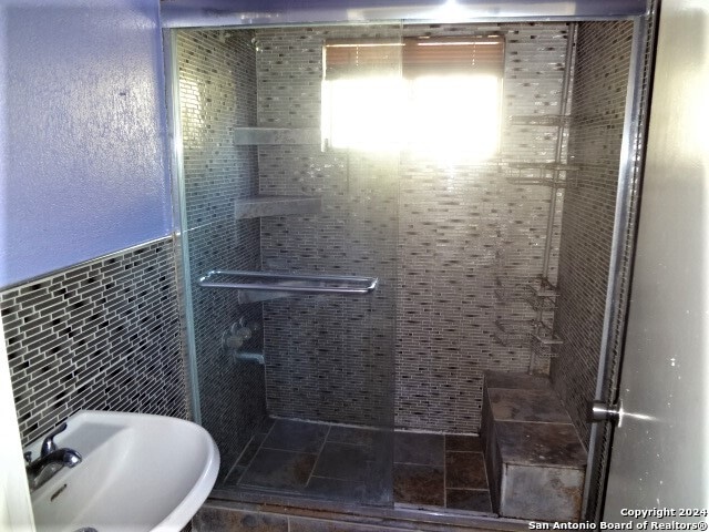 bathroom featuring tile walls, sink, and an enclosed shower