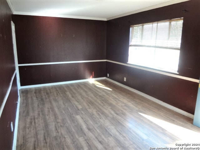 unfurnished room with hardwood / wood-style flooring and ornamental molding