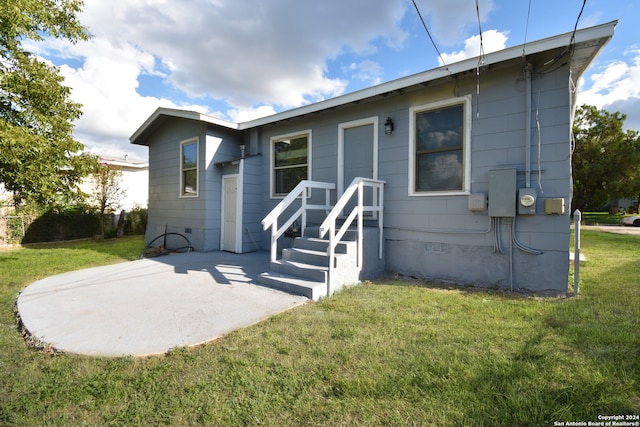 rear view of property featuring a patio and a lawn