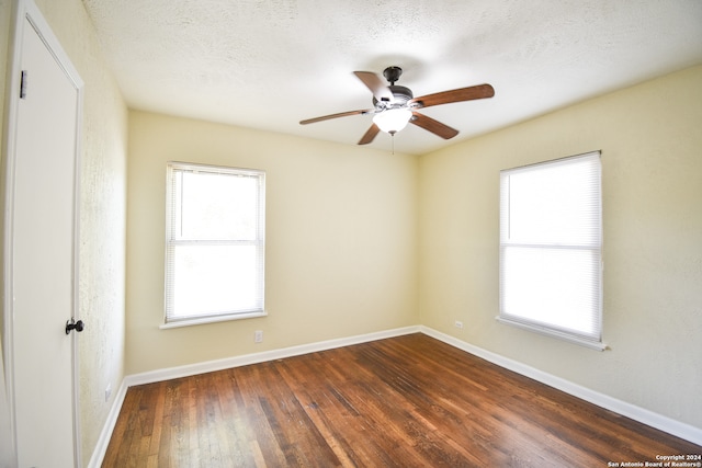 empty room featuring dark wood-type flooring, ceiling fan, and a textured ceiling