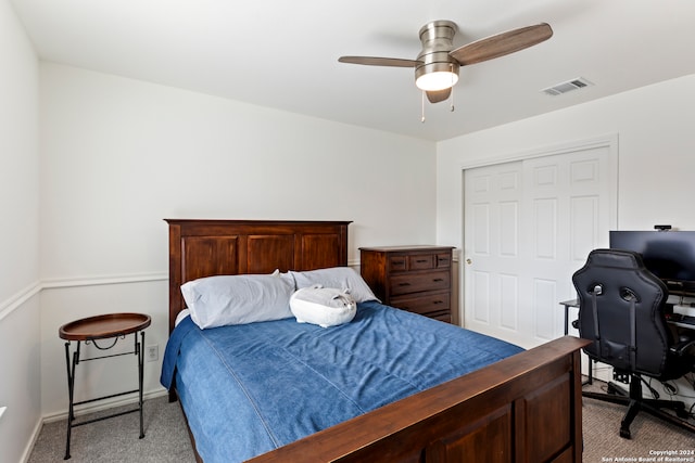 bedroom with ceiling fan, light colored carpet, and a closet