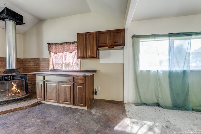 kitchen featuring a wood stove and vaulted ceiling