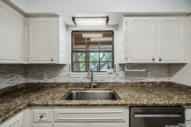 kitchen with stainless steel dishwasher, white cabinetry, sink, and tasteful backsplash