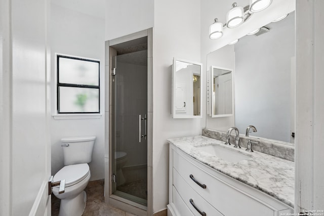 bathroom featuring a shower with door, vanity, and toilet