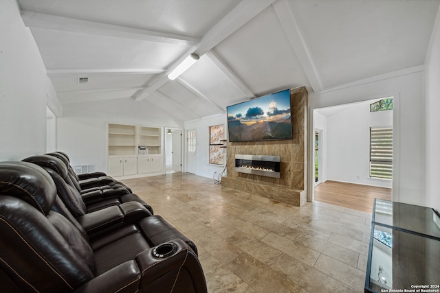 living room featuring lofted ceiling with beams, a large fireplace, a wealth of natural light, and built in features