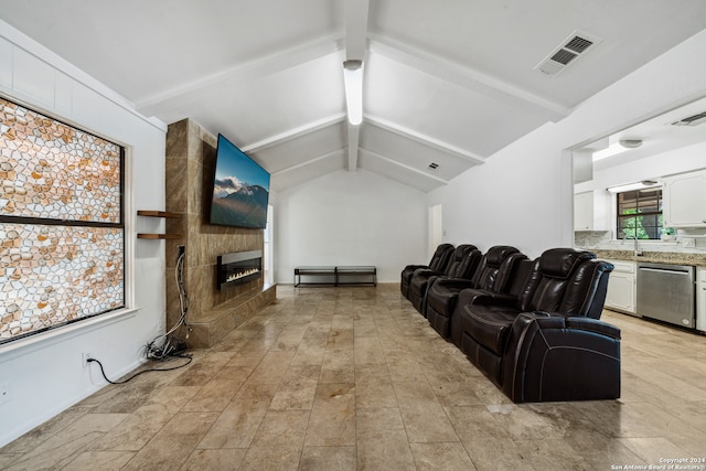 interior space with vaulted ceiling with beams, a fireplace, and sink