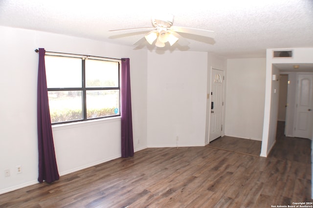 unfurnished room featuring ceiling fan, a textured ceiling, and dark hardwood / wood-style floors