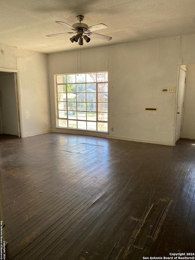 unfurnished room with a textured ceiling, dark hardwood / wood-style floors, and ceiling fan