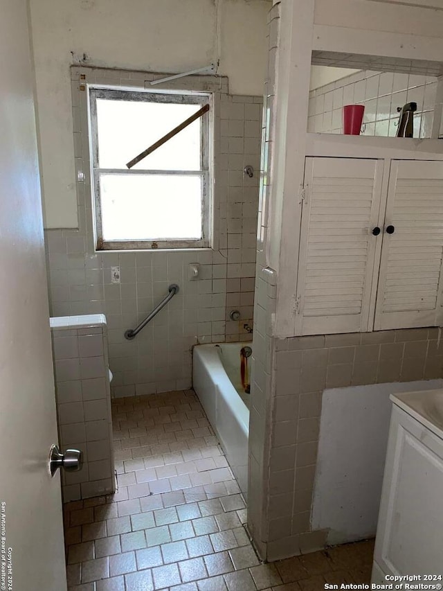 bathroom featuring tile walls, tile patterned floors,  shower combination, and vanity