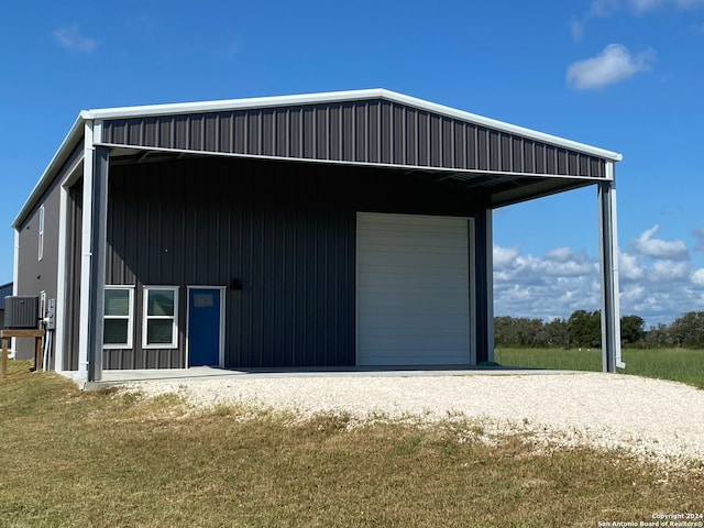 exterior space featuring a lawn, wooden walls, and central air condition unit