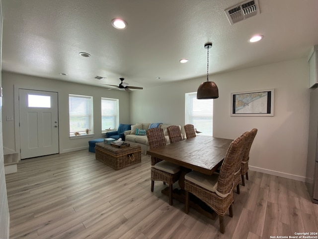 dining room with light hardwood / wood-style flooring, ceiling fan, and a textured ceiling