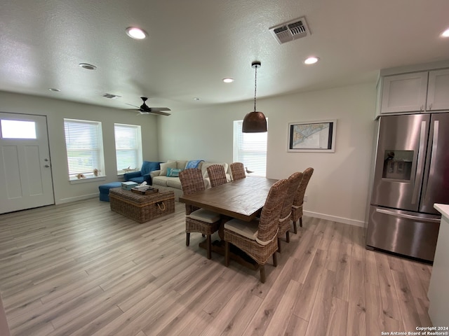 dining area featuring a textured ceiling, light hardwood / wood-style floors, and ceiling fan