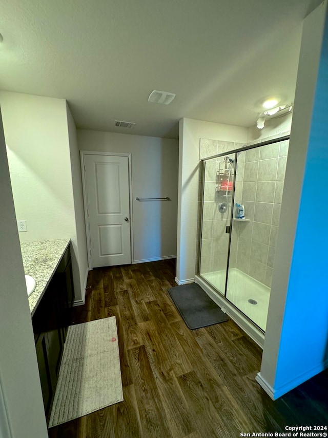 bathroom featuring a shower with shower door, vanity, and hardwood / wood-style flooring