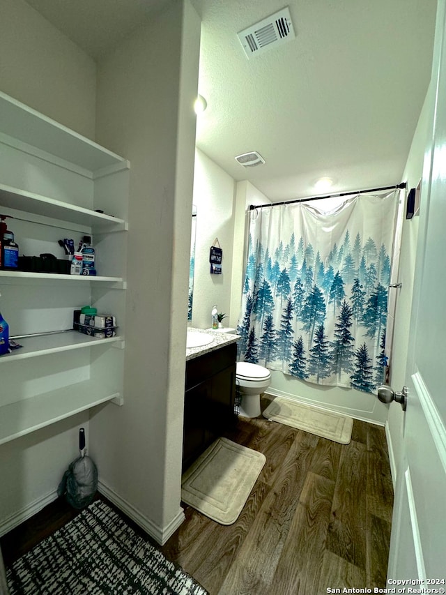 full bathroom featuring vanity, wood-type flooring, shower / tub combo, and toilet