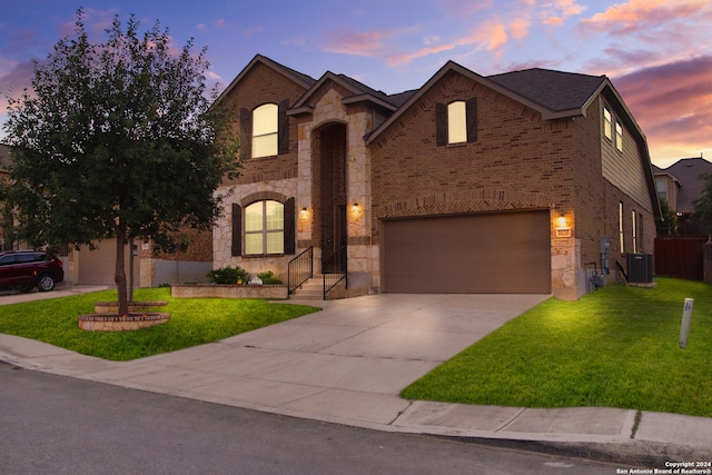 view of front of house with a lawn, a garage, and central AC unit