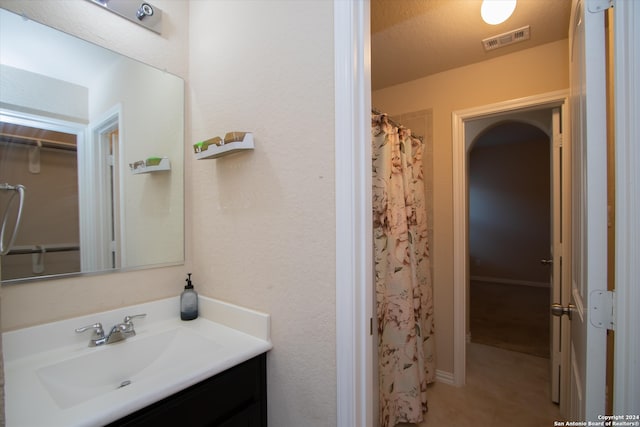 bathroom featuring a shower with curtain, vanity, and a textured ceiling