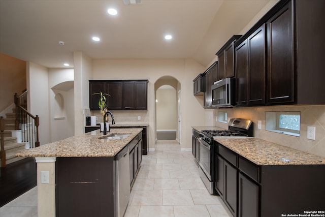 kitchen featuring light stone countertops, a kitchen island with sink, stainless steel appliances, and sink