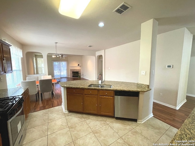 kitchen with light hardwood / wood-style flooring, dishwasher, gas range oven, and sink