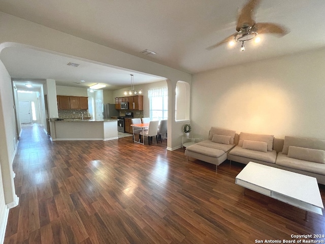 unfurnished living room featuring ceiling fan and dark hardwood / wood-style floors