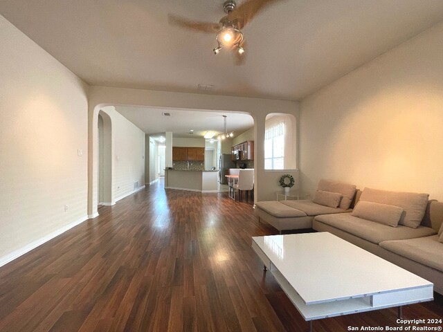 unfurnished living room featuring ceiling fan and dark hardwood / wood-style flooring