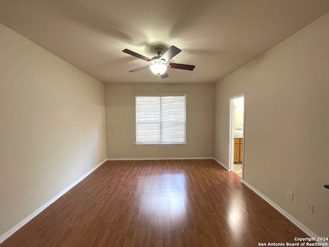 empty room featuring ceiling fan and dark wood-type flooring