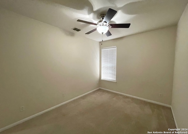 carpeted spare room with ceiling fan