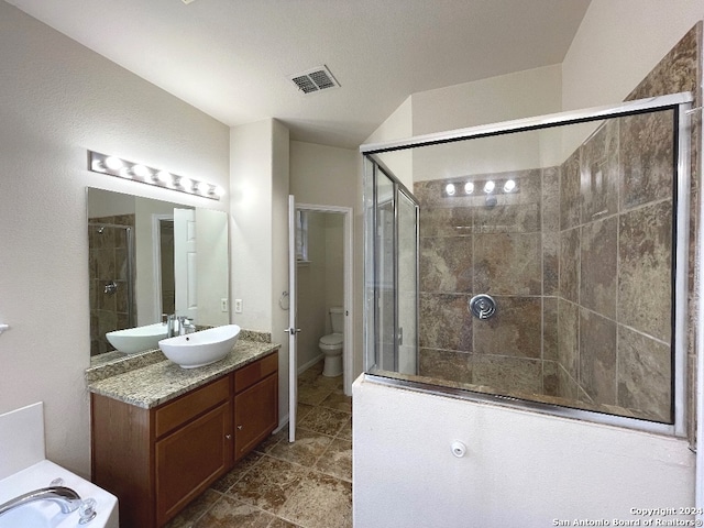 bathroom with a shower with door, vanity, and toilet