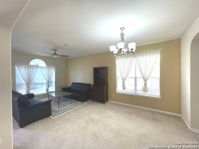 20630 Cliff Park, San Antonio, TX 78258 - living area with carpet floors, arched walkways, baseboards, and ceiling fan with notable chandelier