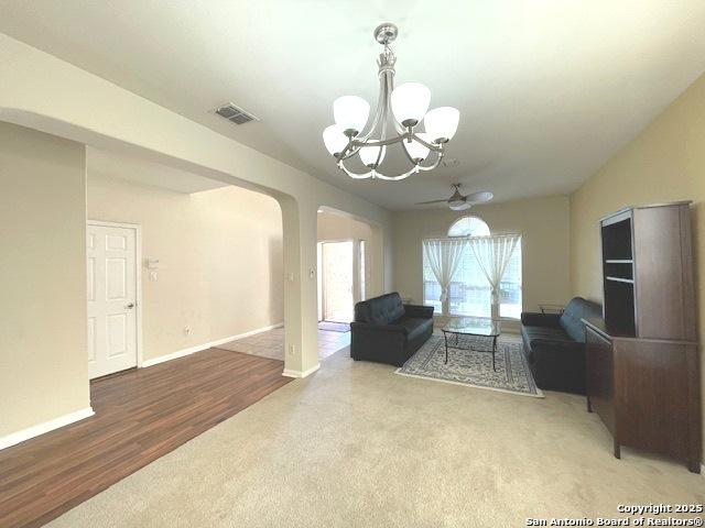 20630 Cliff Park, San Antonio, TX 78258 - living room featuring visible vents, arched walkways, baseboards, carpet floors, and ceiling fan with notable chandelier