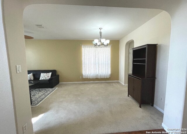 carpeted dining area with a chandelier