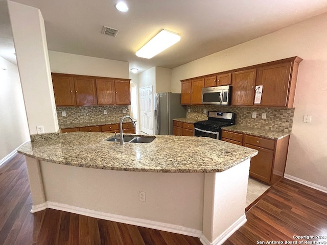 kitchen featuring stainless steel appliances, sink, kitchen peninsula, and decorative backsplash