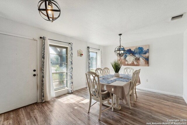 dining room with wood-type flooring and a chandelier