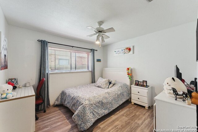 bedroom with wood-type flooring and ceiling fan