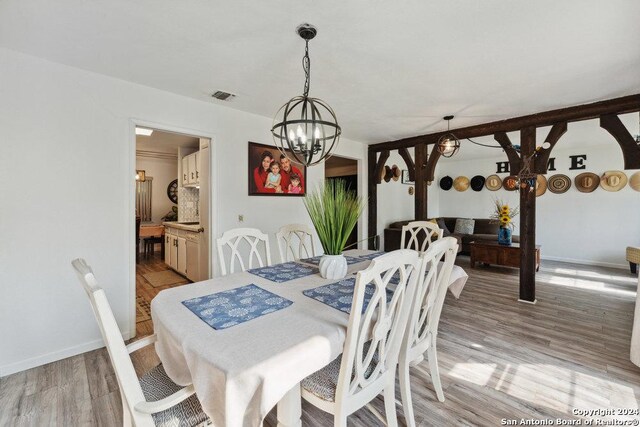 dining space with a notable chandelier and light hardwood / wood-style floors