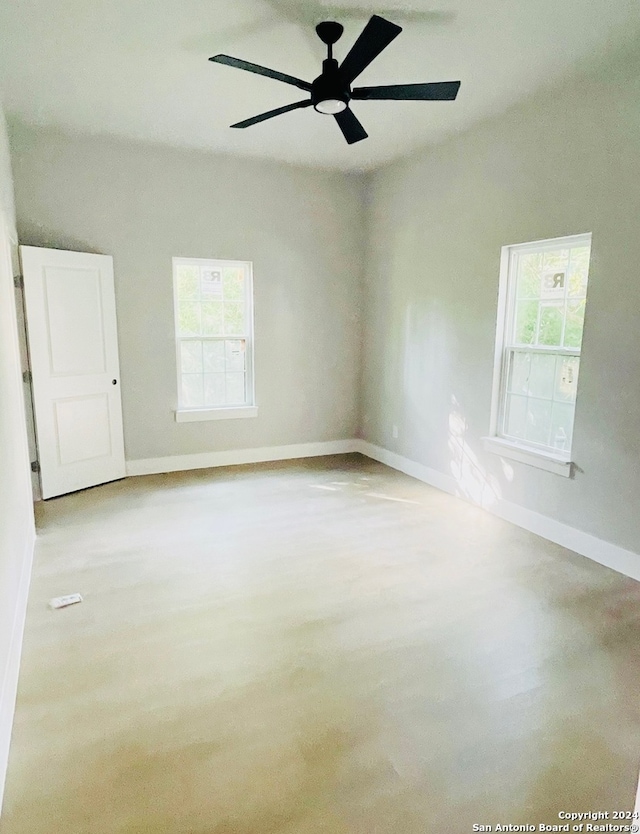 unfurnished room featuring a wealth of natural light and ceiling fan