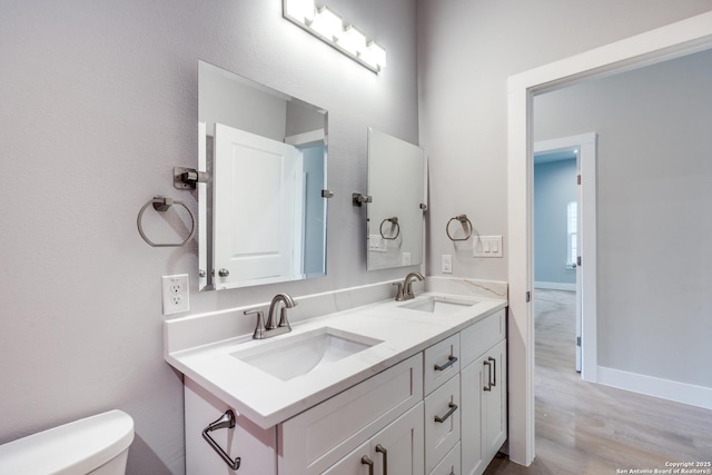 bathroom with vanity, hardwood / wood-style flooring, and toilet