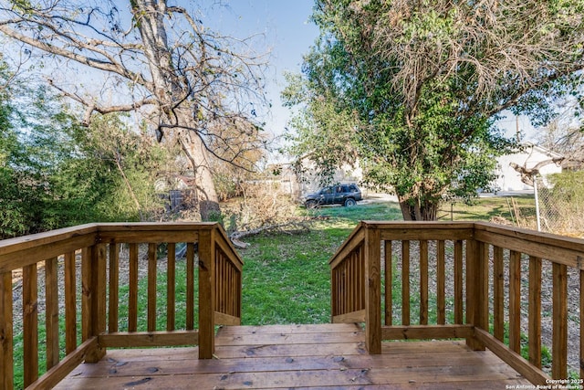 wooden terrace featuring a lawn