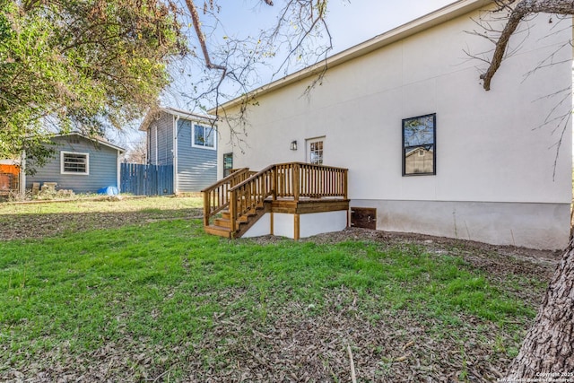 rear view of property featuring a lawn and a deck