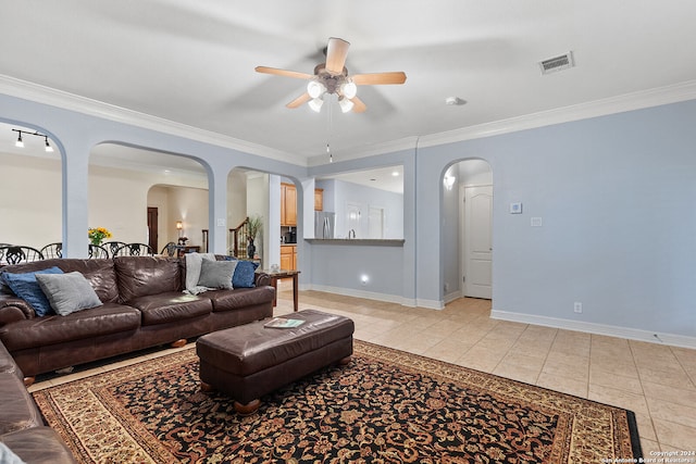 living room featuring ceiling fan, light tile patterned floors, and crown molding