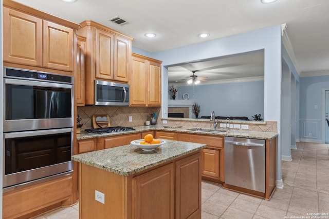 kitchen featuring appliances with stainless steel finishes, decorative backsplash, crown molding, ceiling fan, and sink