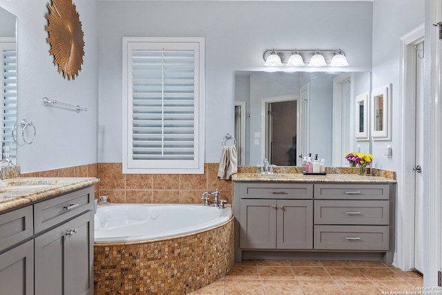 bathroom with vanity, a relaxing tiled tub, and tile patterned floors