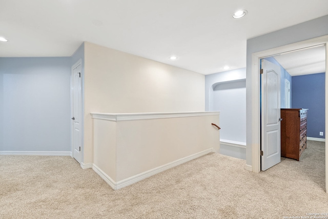 hallway featuring light colored carpet