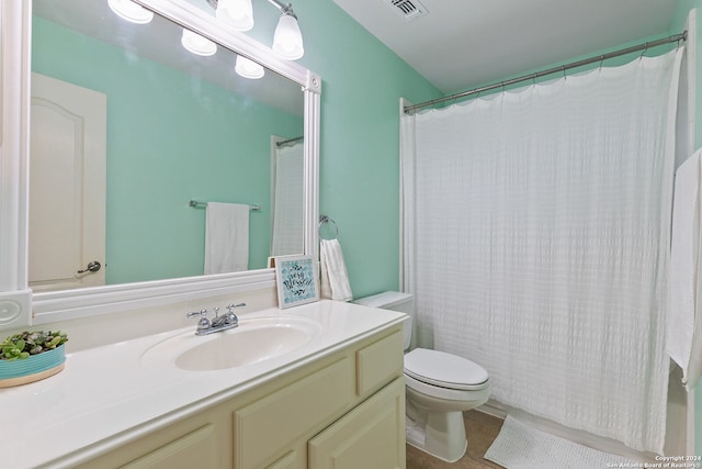 bathroom with a shower with shower curtain, tile patterned floors, vanity, and toilet