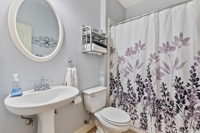 bathroom featuring toilet and curtained shower