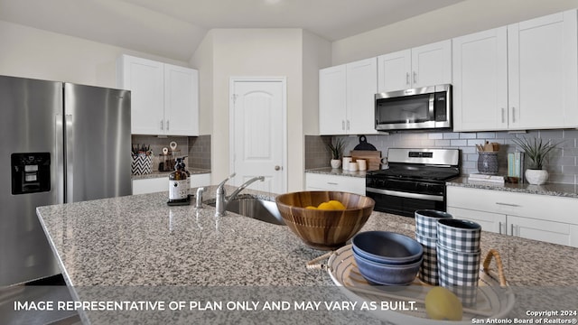 kitchen with light stone counters, white cabinets, appliances with stainless steel finishes, and tasteful backsplash